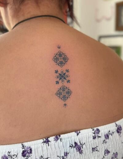 Small azulejo tile tattoos on upper back, Portuguese fine line ornamental tattoo Porto
