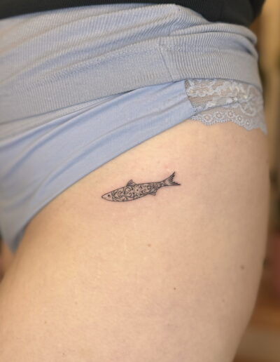 Small fine line sardine tattoo on hip, minimalist azulejo pattern tattoo Porto