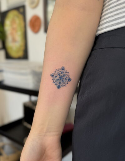 Fine line azulejo tattoo on the arm in Porto – delicate Portuguese tile pattern