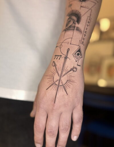Fine line geometric tattoo on forearm with sword and sacred symbols, black and grey tattoo Porto