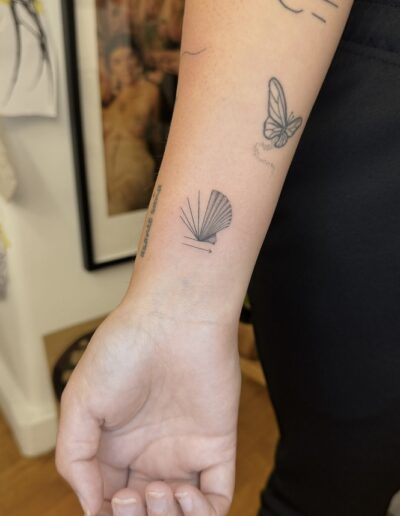 The seashell is more than a symbol — it is the mark of the pilgrim. This delicate pilgrim seashell tattoo by Kateryna Korkach represents the Camino, personal transformation, strength, and the journey toward meaning. Minimalist and elegant, it preserves your pilgrimage not as a souvenir, but as a permanent reminder of who you became along the way. Perfect for those who walked their path with intention and want to carry the spirit of the Camino forever. Subtle, refined, and deeply symbolic.