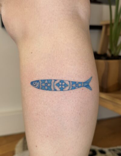 Blue ink sardine tattoo inspired by classic azulejo tiles. A bold yet clean design that reflects Portuguese culture and identity.