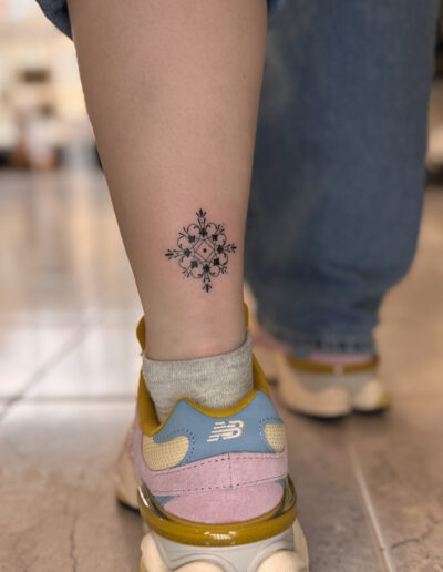 Small azulejo tattoo on ankle, fine line Portuguese tile pattern travel tattoo Porto