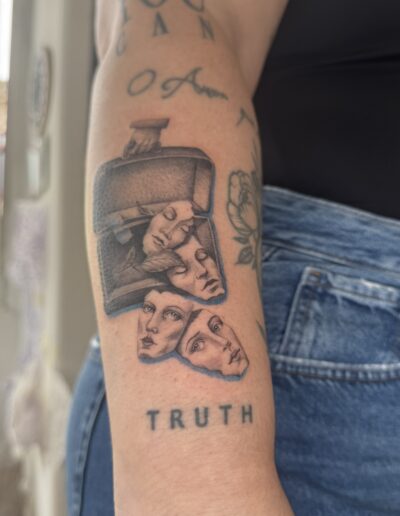 Fine line black and grey tattoo of faces in a bottle on arm in Porto Portugal by KORKACH Kateryna, illustrative surreal design