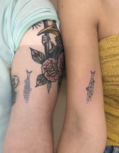 Matching sardine tattoos with azulejo pattern fine line on arms in Porto Portugal by KORKACH Kateryna
